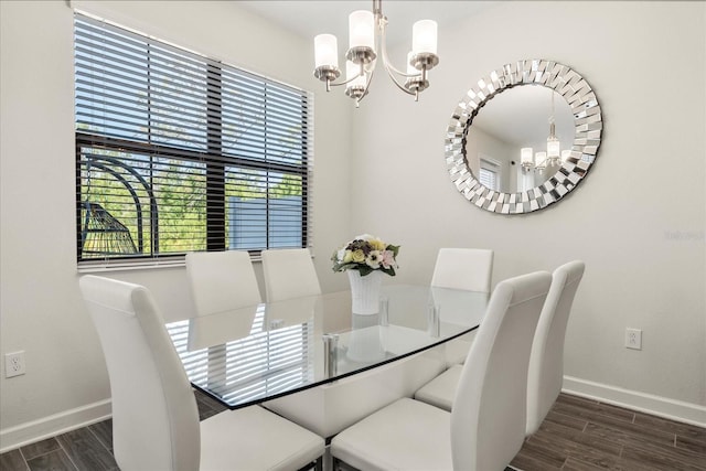 dining room featuring baseboards, wood finished floors, and a notable chandelier