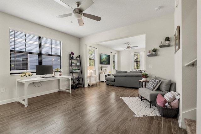living area with baseboards, ceiling fan, wood finished floors, and a healthy amount of sunlight