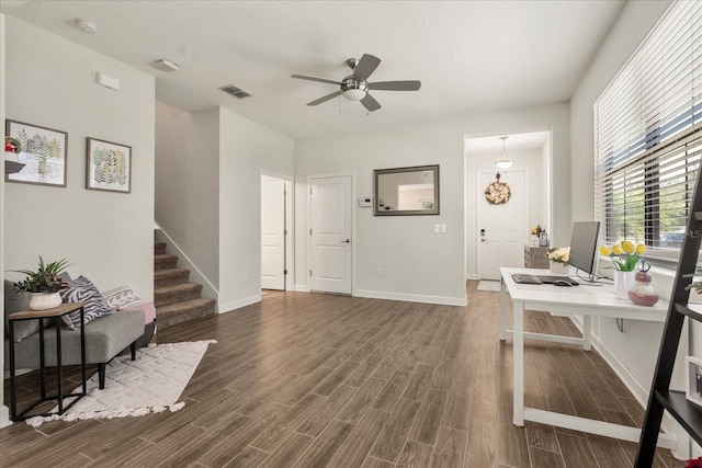office space with a ceiling fan, baseboards, visible vents, and dark wood-style floors