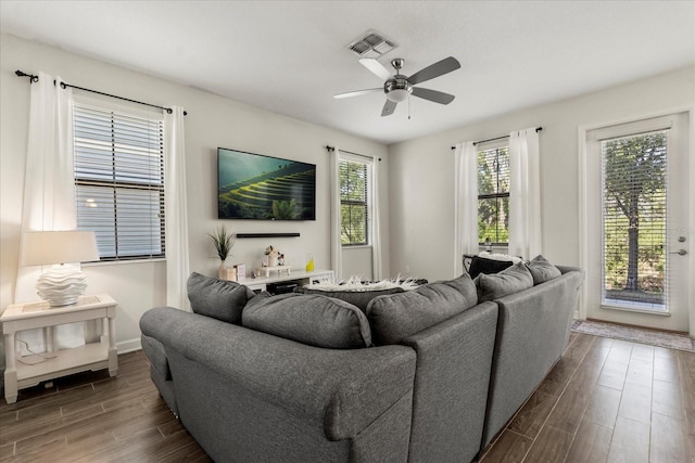 living area with visible vents, dark wood-style flooring, ceiling fan, and baseboards