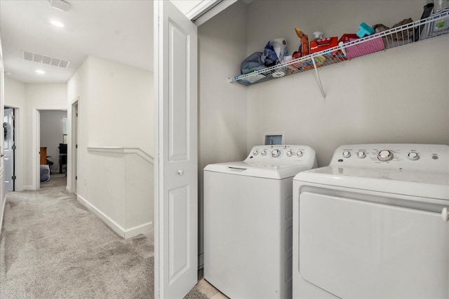 clothes washing area featuring laundry area, visible vents, light carpet, baseboards, and separate washer and dryer