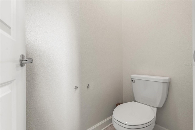 bathroom with baseboards and toilet