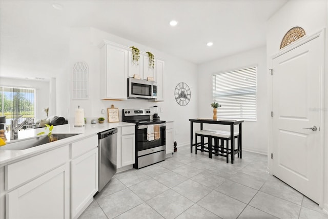 2156 Merrybells Dr, Kissimmee, FL 34746 - kitchen featuring appliances with stainless steel finishes, a sink, light countertops, white cabinets, and recessed lighting