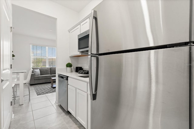 2156 Merrybells Dr, Kissimmee, FL 34746 - kitchen featuring stainless steel appliances, light countertops, white cabinets, and light tile patterned flooring