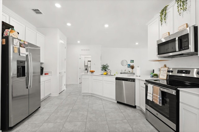 2156 Merrybells Dr, Kissimmee, FL 34746 - kitchen with stainless steel appliances, a peninsula, recessed lighting, light countertops, and white cabinetry