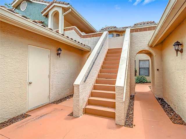 entrance to property featuring stucco siding and a tiled roof