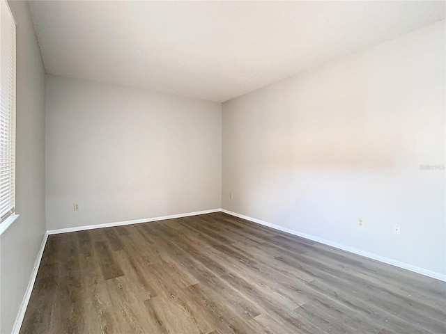 unfurnished room with baseboards and wood finished floors