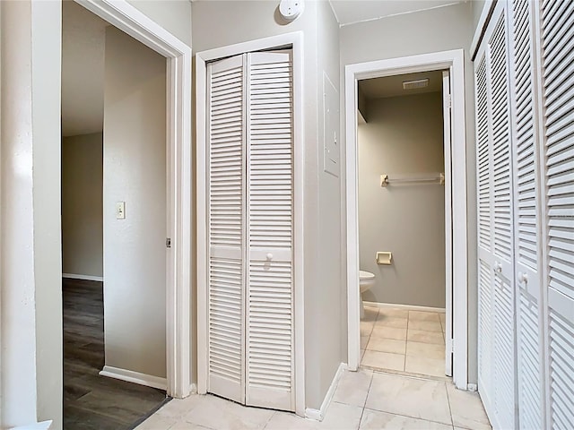bathroom featuring toilet, baseboards, visible vents, and a closet