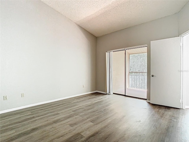 unfurnished room featuring baseboards, a textured ceiling, and wood finished floors