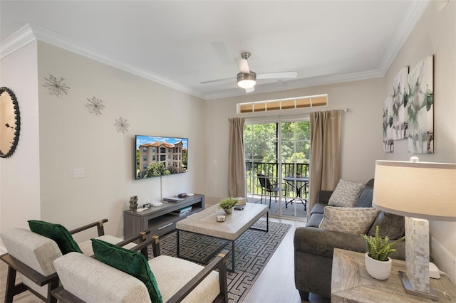 living area with crown molding, a ceiling fan, and wood finished floors