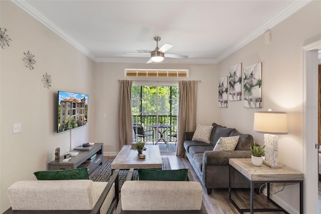 living room with baseboards, ornamental molding, a ceiling fan, and wood finished floors