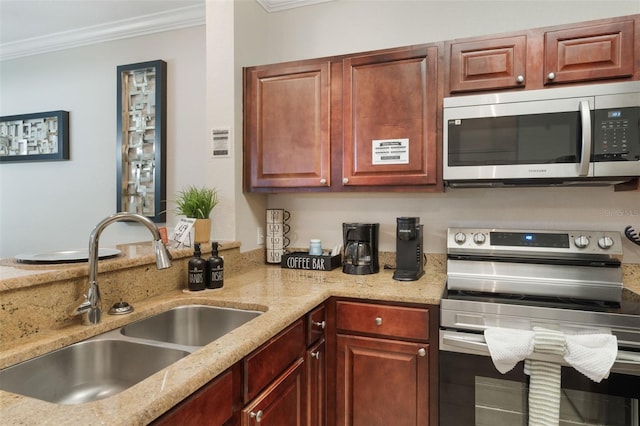 kitchen featuring crown molding, a sink, light stone countertops, and stainless steel appliances