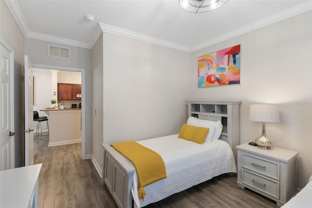 bedroom with visible vents, ornamental molding, baseboards, and dark wood-style floors