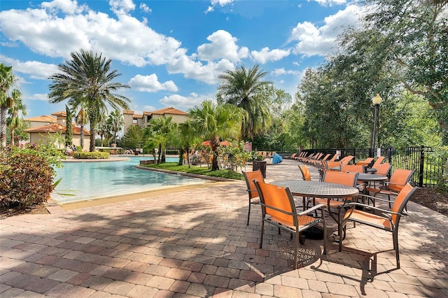 pool featuring fence, a patio, and outdoor dining area