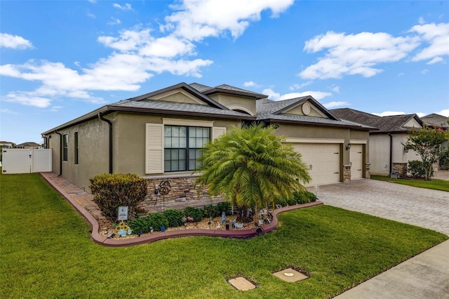 view of front of property with a front yard, a gate, decorative driveway, an attached garage, and stucco siding