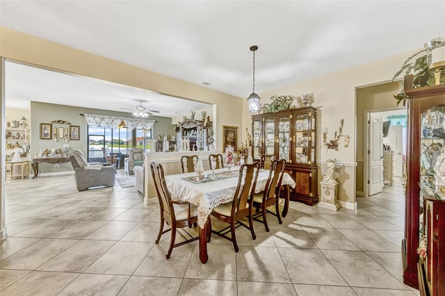 dining space with baseboards, ceiling fan, and light tile patterned flooring