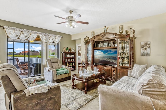 living area with a ceiling fan and light tile patterned floors