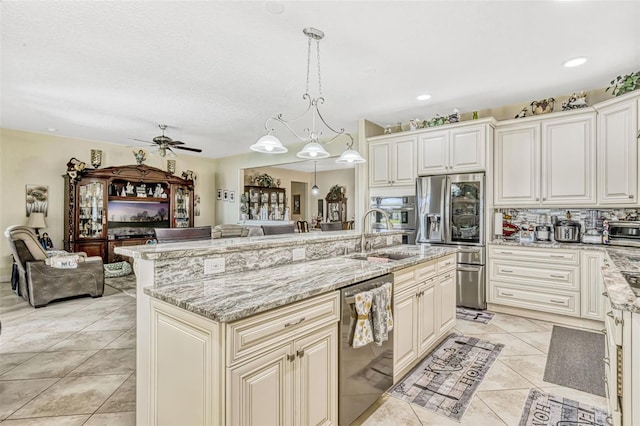 kitchen featuring a sink, ceiling fan, stainless steel appliances, and open floor plan