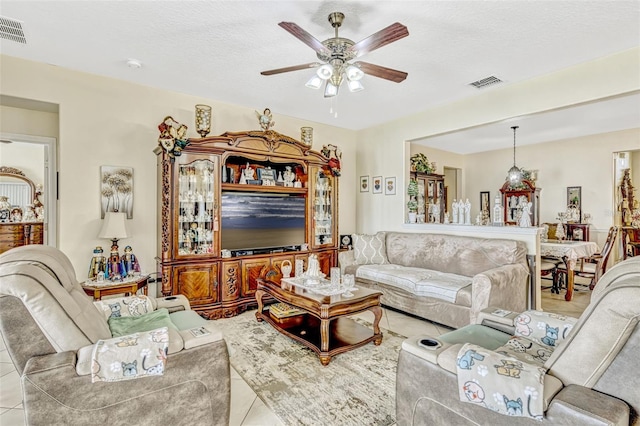 living area featuring ceiling fan, visible vents, and tile patterned flooring