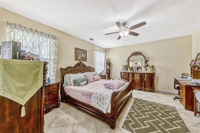 bedroom featuring light tile patterned floors, a ceiling fan, a textured ceiling, and visible vents