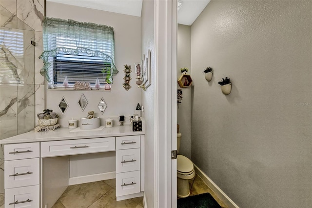 bathroom featuring tile patterned flooring, walk in shower, toilet, and vanity
