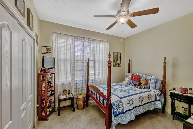 bedroom featuring a closet, a ceiling fan, a textured ceiling, and baseboards