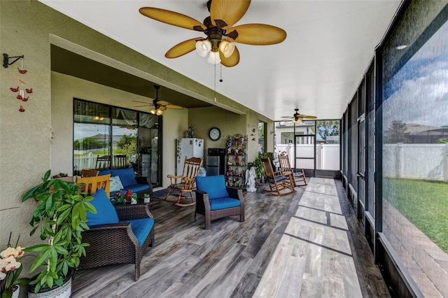 sunroom featuring plenty of natural light and a ceiling fan