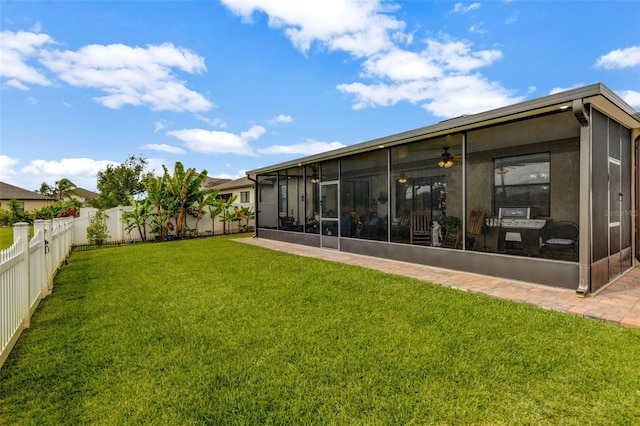 exterior space featuring a sunroom, a fenced backyard, and a lawn