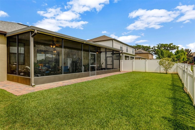 back of house with a sunroom, a fenced backyard, ceiling fan, and a yard