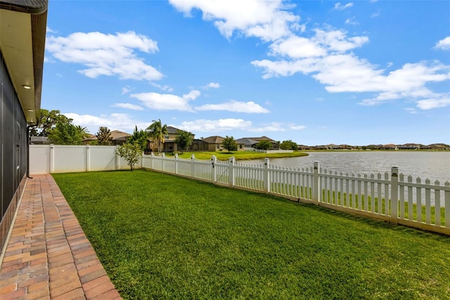 view of yard featuring a water view and a fenced backyard