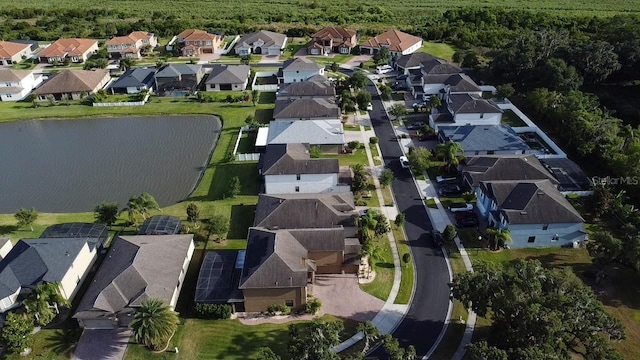 drone / aerial view featuring a water view, a view of trees, and a residential view