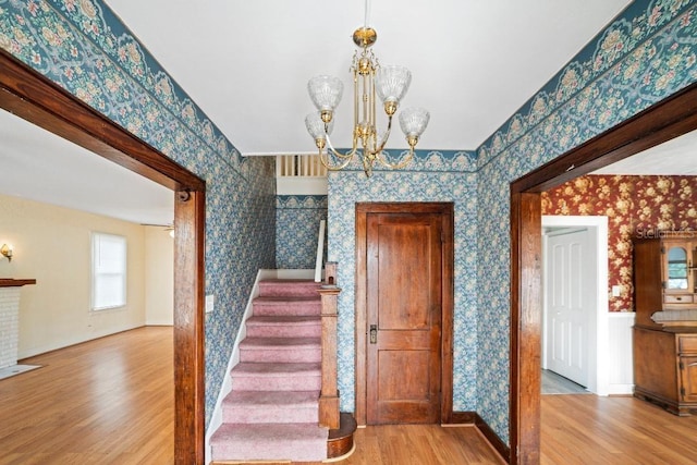 1400 Florida Ave, Saint Cloud, FL 34769 - stairway with wallpapered walls, wood finished floors, and a chandelier