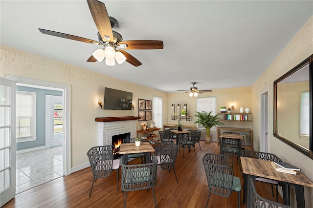 1400 Florida Ave, Saint Cloud, FL 34769 - dining space featuring a fireplace, a ceiling fan, wood finished floors, and baseboards