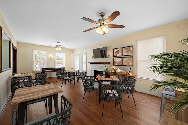 1400 Florida Ave, Saint Cloud, FL 34769 - dining area featuring wood finished floors, a fireplace, baseboards, and a ceiling fan