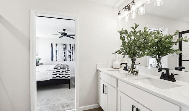 bathroom with vanity, a ceiling fan, baseboards, and ensuite bathroom