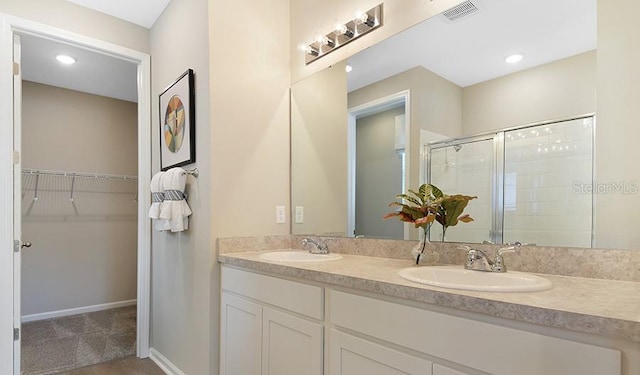 full bath with a walk in closet, visible vents, a shower stall, and a sink