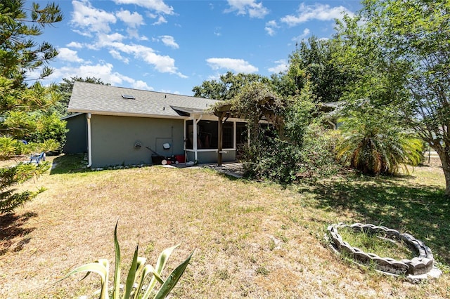 1100 Anne Elisa Cir, Saint Cloud, FL 34772 - rear view of house with a yard, a shingled roof, a sunroom, and stucco siding
