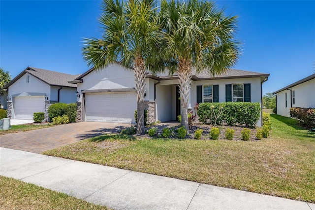 view of front of home with a garage, stucco siding, driveway, and a front lawn
