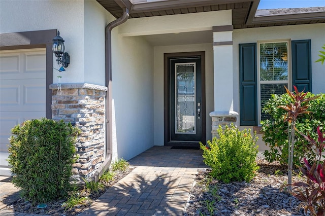 view of exterior entry featuring stucco siding and stone siding