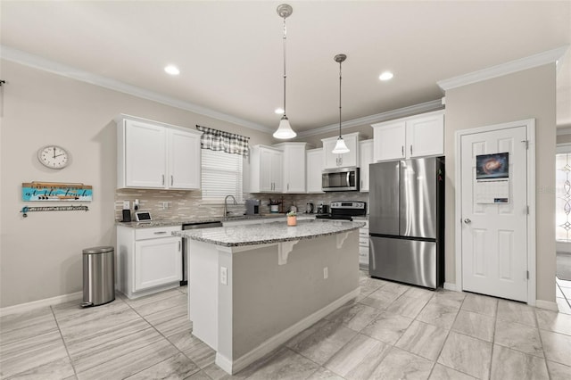 kitchen with a sink, appliances with stainless steel finishes, white cabinets, and crown molding