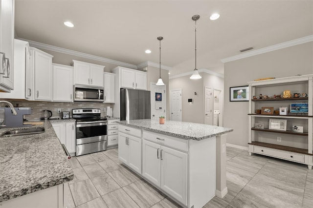 kitchen with crown molding, decorative backsplash, a kitchen island, a sink, and appliances with stainless steel finishes