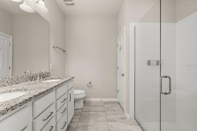 bathroom featuring a sink, a stall shower, toilet, and double vanity