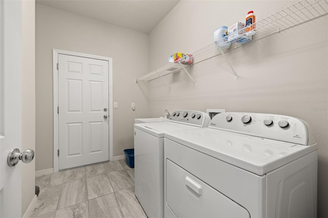 washroom with laundry area, washing machine and clothes dryer, a sink, baseboards, and marble finish floor