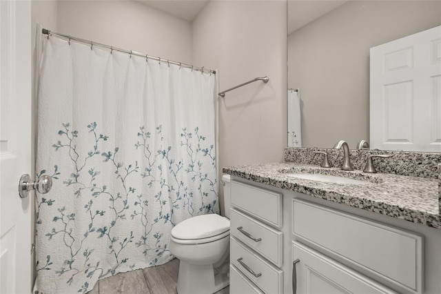 bathroom with toilet, a shower with shower curtain, and vanity