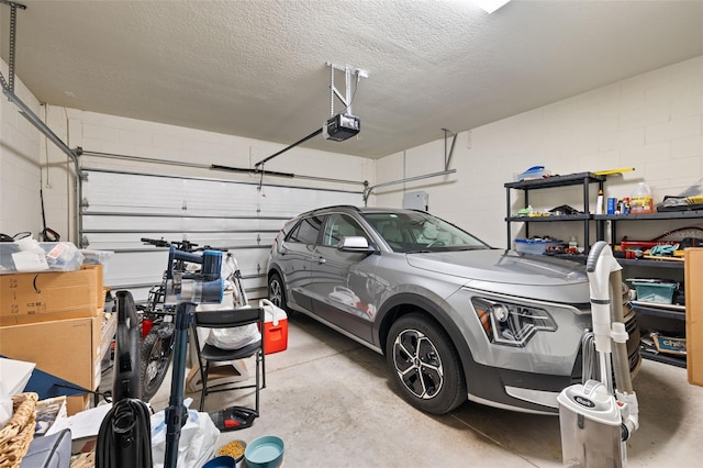 garage featuring concrete block wall and a garage door opener