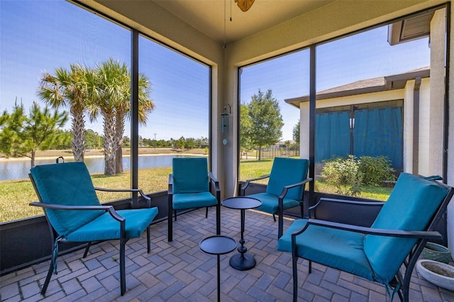 sunroom / solarium with a water view and ceiling fan