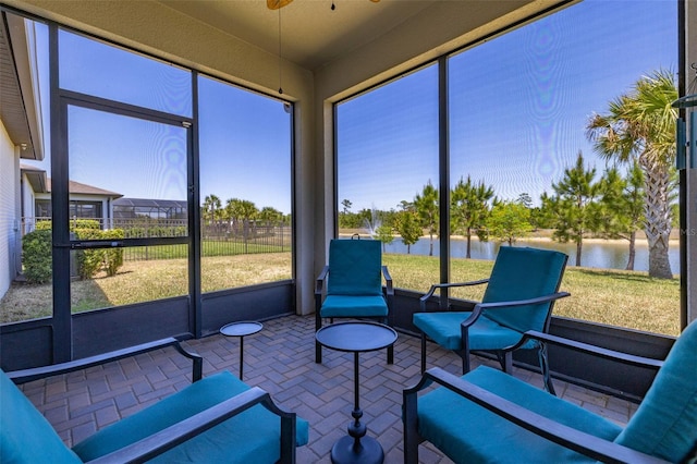 sunroom with a water view and a ceiling fan