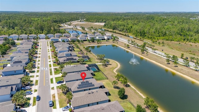 birds eye view of property with a water view, a view of trees, and a residential view