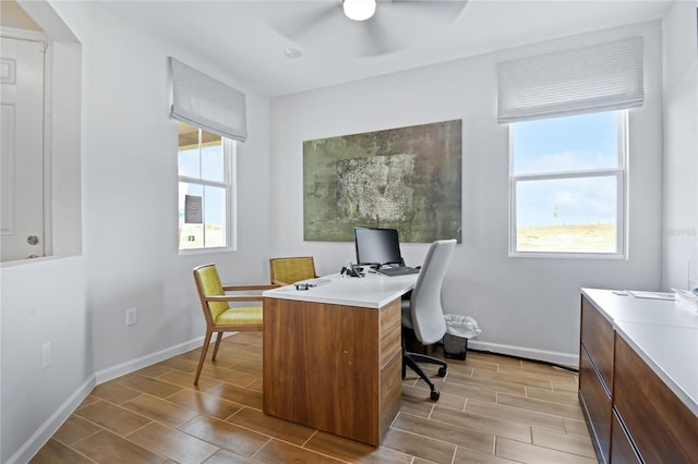 office area featuring a healthy amount of sunlight, baseboards, and ceiling fan