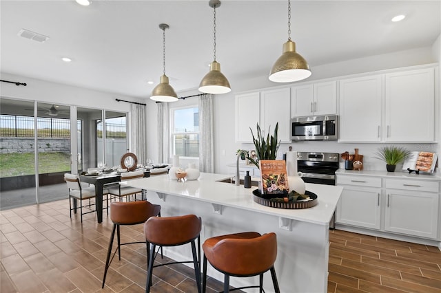 kitchen with a sink, light countertops, stainless steel appliances, recessed lighting, and visible vents
